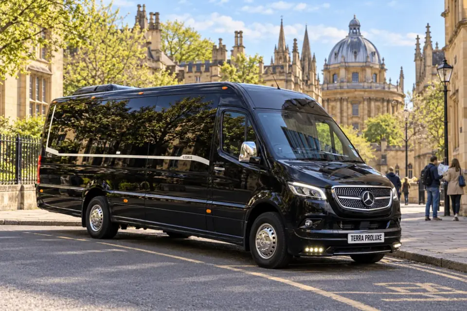 Black Mercedes-Benz Sprinter parked beside historic city-centre buildings.
