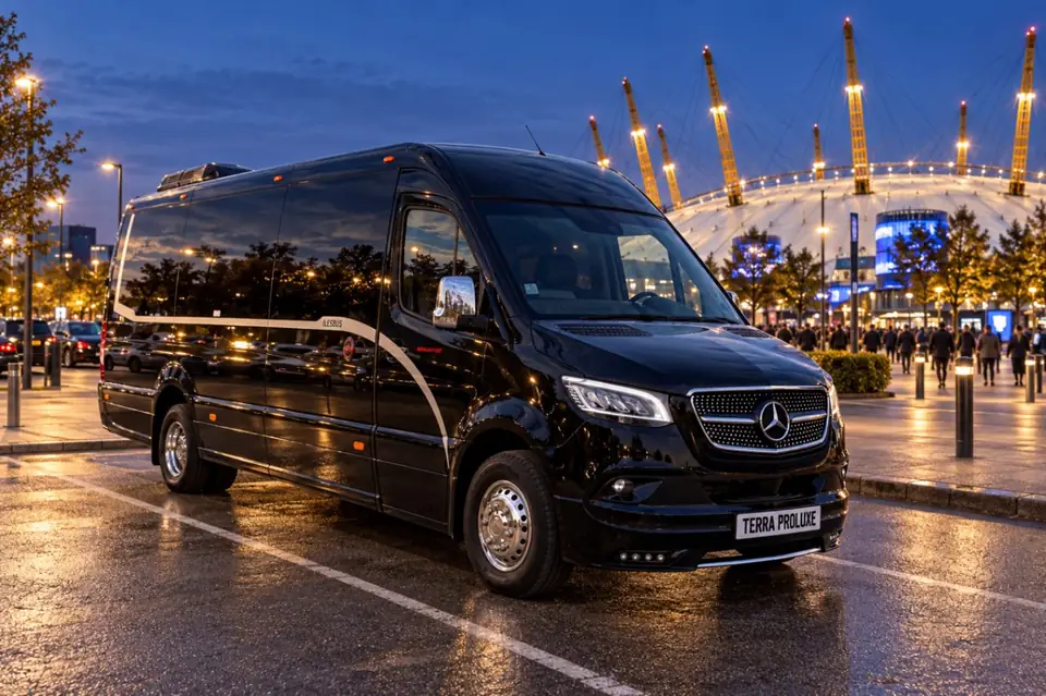 Black Mercedes-Benz Sprinter near an arena in the evening.