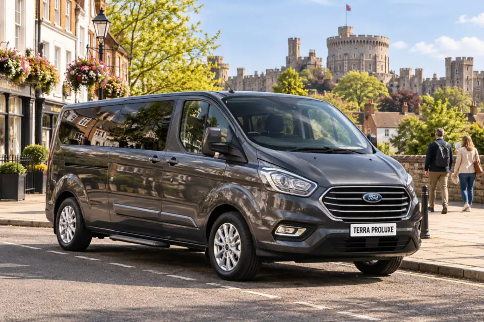 Grey Ford Tourneo Custom in a town street with a castle behind.