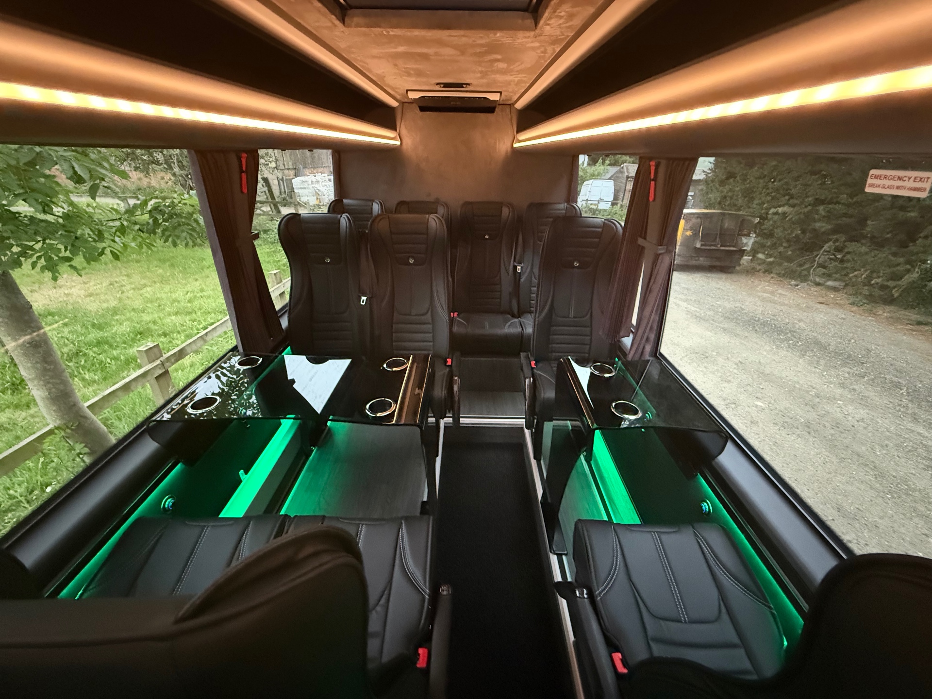 Glass tables and club-style seating with green ambient lighting