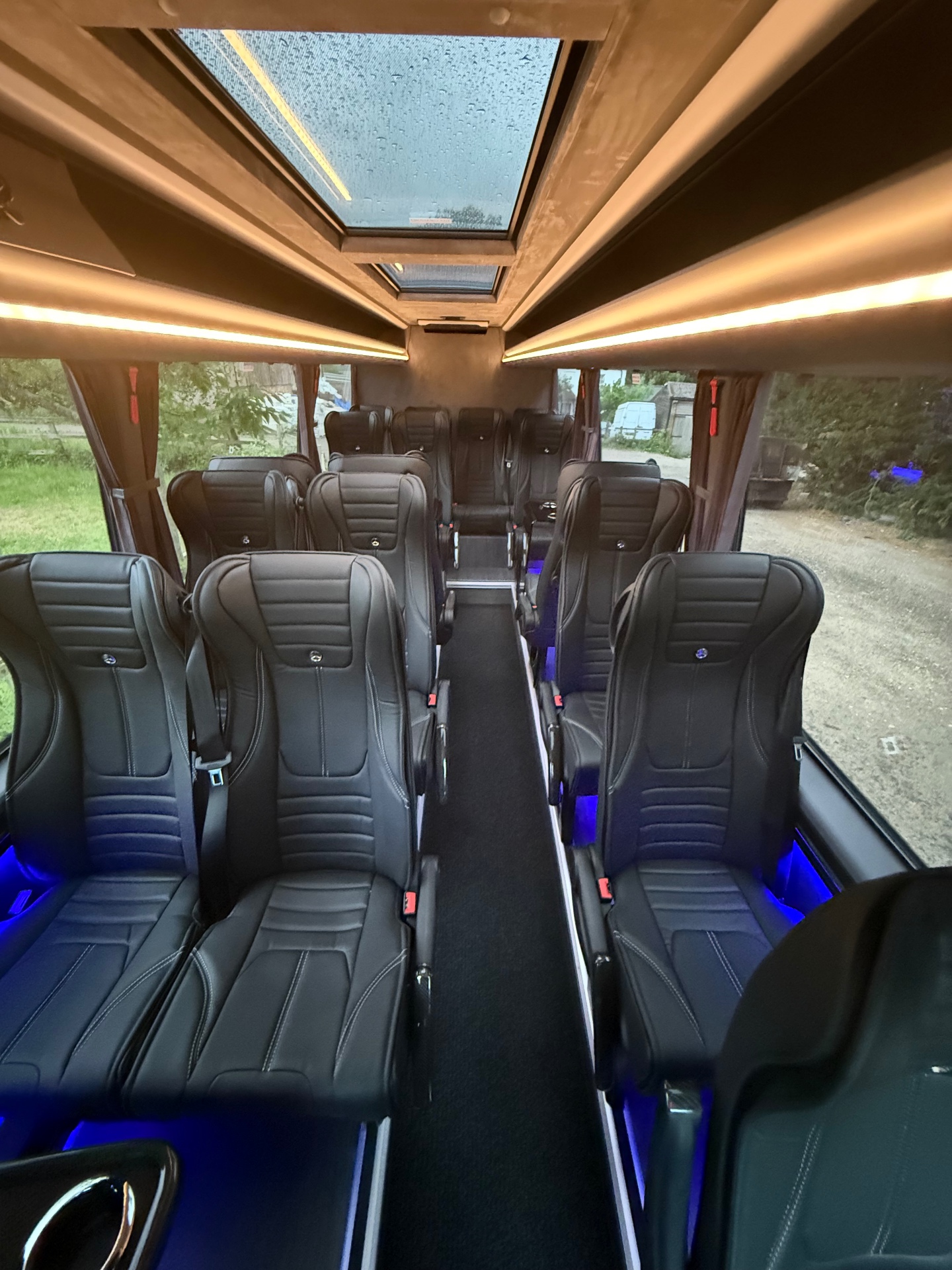 Forward-facing leather seating rows with three-point seat belts inside the 16-seat Sprinter